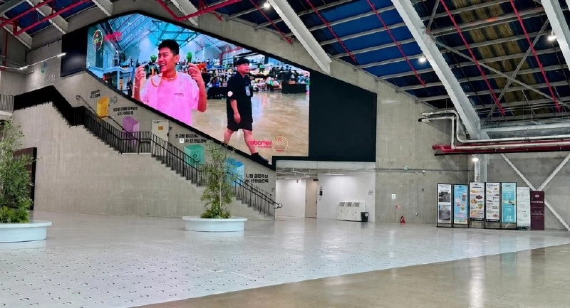 天井の高いサンサンプラットフォームの館内。大型スクリーンと階段がある広いホール
