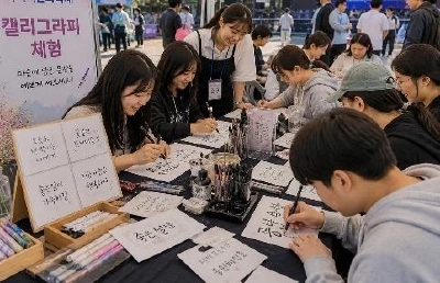 長机に並んだ参加者たちが筆ペンでカリグラフィーを書いている様子